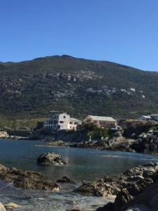 ein Wasserkörper vor einem Berg in der Unterkunft Villa Marie Cap Corse sentier douaniers in Centuri