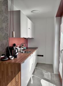 - une cuisine avec des placards blancs et un évier dans l'établissement Il Nido del Pettirosso - by Osteria del Pettirosso, à Rovereto