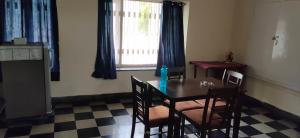 a dining room with a table and chairs and a window at The Ghosh's Home stay in Hyderabad