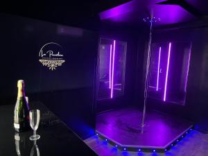 ein lila Zimmer mit einer Flasche Wein und einem Weinglas in der Unterkunft Love room La Parenthèse Carnoules in Carnoules