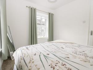 a white bedroom with a bed and a window at Ramblers Rest in Sedbergh