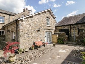 a stone building with a bench in front of it at Ramblers Rest in Sedbergh