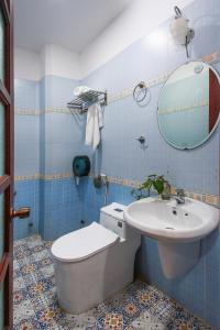een badkamer met een toilet, een wastafel en een spiegel bij Grandma Lu Saigon - Bui Vien Walking Street in Ho Chi Minh-stad