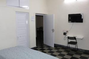 a bedroom with a bed and a desk and a television at The Ghosh's Home stay in Hyderabad