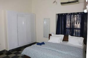 Un dormitorio con una cama con una cinta azul. en The Ghosh's Home stay, en Hyderabad