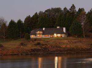 a large house on a field with a river at Rivermead in Himeville