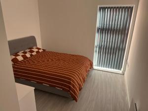 a small bedroom with a bed and a window at Luxe City Centre in Birmingham