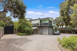 a house with a car parked in the driveway at Balclutha in Point Lonsdale