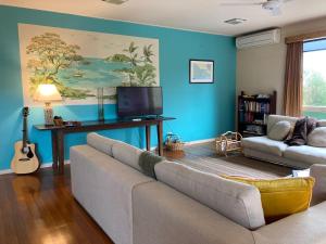 a living room with a couch and a tv at Balclutha in Point Lonsdale