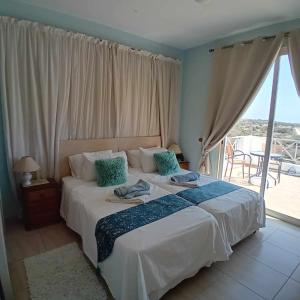 a bedroom with a large bed with a balcony at Sunset Boutique Guest House in Paphos City