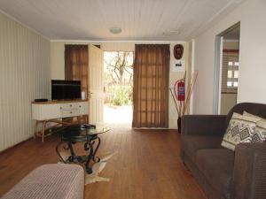 uma sala de estar com um sofá e uma televisão em Lush Bush at Loodswaai Cullinan close to Dinokeng em Rust de Winter