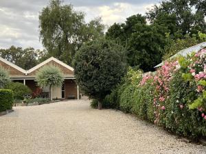 Willunga的住宿－1839 Cottages，一座带灌木和鲜花的花园的房子