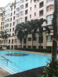 a large blue swimming pool in front of a building at 1BR Condo at Montecito Newport City Residential Resort across NAIA and Marriott Hotel in Manila