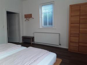 a white bedroom with a bed and a window at Kleine Auszeit in Bad Fallingbostel