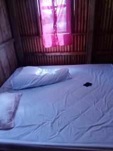 Cama en habitación con ventana rosa en RAMMANG-RAMMANG HOUSE en Maros