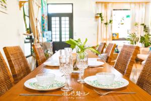 uma mesa de madeira com pratos e copos em On The Way Guesthouse em Magong