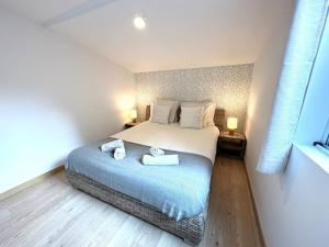 a bedroom with a bed with two towels on it at 5- Hypercentre - 4pers - clim - terrasse - Netflix in Libourne