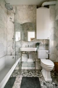 a bathroom with a toilet and a sink and a shower at Design-led flat in Camden on quiet street in London