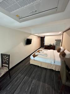 a hotel room with a bed and a tv at Maleez Lodge in Pattaya