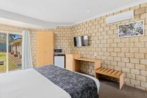a hotel room with a bed and a tv at Great Divide Motor Inn in Toowoomba