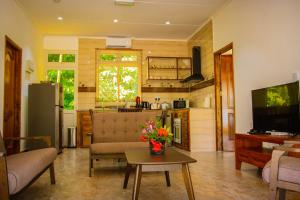 a living room with a couch and a table at Macmillan's Holiday Villas in Grand'Anse Praslin