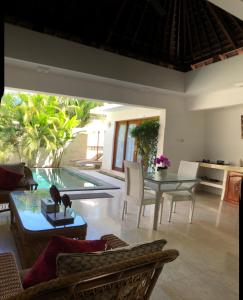 a living room with a table and a swimming pool at Jivana Resort in Kuta Lombok