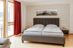 1 dormitorio con 1 cama grande y cortinas rojas en Weingut Eduard Kroth, en Briedel