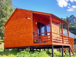 uma pequena cabina de madeira com uma grande janela em Guesthouse and Cottage Nicolo em Stepantsminda