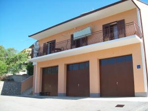 un edificio con 4 puertas de garaje y balcón en Rooms MUDRAC en Senj