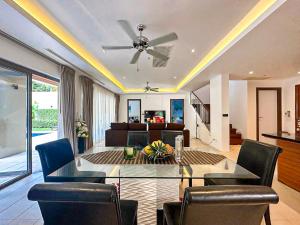 - un salon avec un ventilateur de plafond, une table et des chaises dans l'établissement Wonderful villa Harmony BangTao beach, à Bang Tao Beach