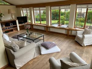 a living room with couches and a table and windows at Ferienhaus Altenmarktblick in Altenmarkt im Pongau