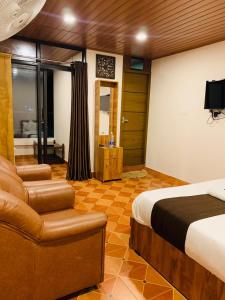 - une chambre avec un lit, un canapé et une chaise dans l'établissement LetStay Misty Wind Holiday Homes, à Vythiri