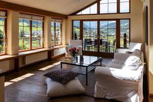 una sala de estar con muebles blancos y ventanas grandes. en Ferienhaus Altenmarktblick en Altenmarkt im Pongau