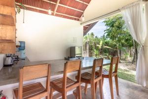 a kitchen with a table and chairs and a window at Ohana Resort Siargao in General Luna