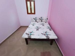 a small bed in a corner of a room at Hotel O Homes Maithli Raman Kunj Homestay in Ayodhya