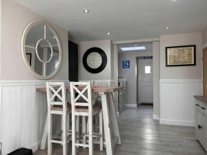 uma cozinha com uma mesa, bancos e um espelho em 3 Bedroom Cottage in Conwy with Parking Sleeps 4 em Conwy