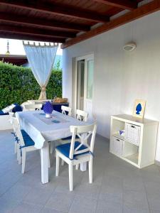 un tavolo bianco e sedie su un patio di Dolcevita Villa in Vulcano a Vulcano