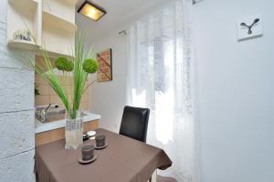 a dining room with a table and a vase with a plant at Apartments Donat in Zadar