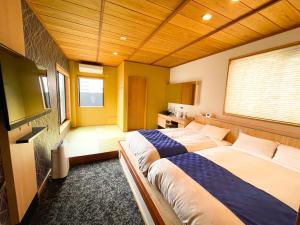 a bedroom with two beds and a television in it at NK Hotels in Fukuoka