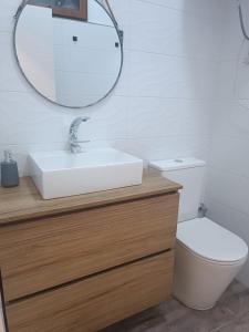 een badkamer met een wastafel, een toilet en een spiegel bij MCR in Isla Cristina