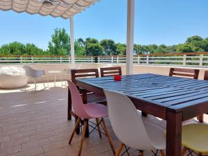 un tavolo e sedie in legno su un patio di Interno H10 - Olimpia Residence a Policoro