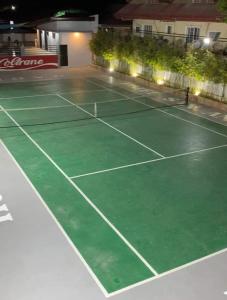 una pista de tenis iluminada por la noche en JJPHR Hotel San Antonio en Lubao