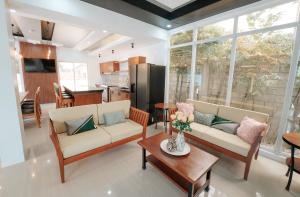 a living room with two couches and a table at JJPHR Hotel San Antonio in Lubao