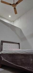 a ceiling fan in a room with a bed at OYO S K Hotel in Morādābād