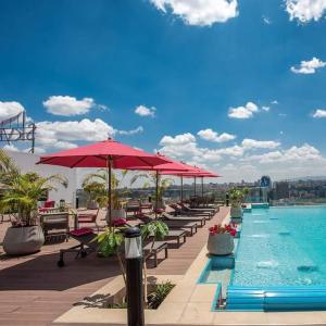 una fila di sedie e ombrelloni accanto alla piscina di Skynest Residences Entire Furnished Apartment, Westlands a Nairobi