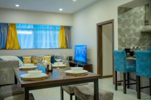 a dining room with a table and blue chairs at Skynest Residences Entire Furnished Apartment, Westlands in Nairobi