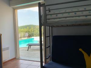 a bedroom with a bunk bed and a view of a pool at Villa Corbieres in Durban-Corbières