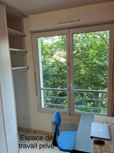 Habitación con ventana, mesa y silla azul. en Wilson New Home, en Saint-Denis