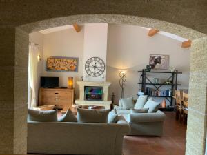 a living room with couches and a clock on the wall at Villa Corbieres in Durban-Corbières