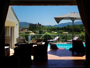a patio with a view of a pool and an umbrella at Villa Corbieres in Durban-Corbières